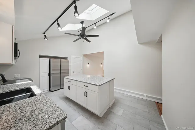 a kitchen with stainless steel appliances granite countertop a refrigerator and a stove