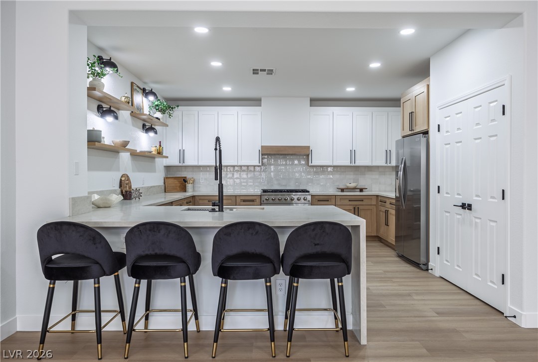 10982 Village Ridge Lane Las Vegas, NV 89135 - Photo 4 of 12 A well-lit kitchen with sleek countertops, modern cabinetry, and integrated appliances awaits culinary adventures.