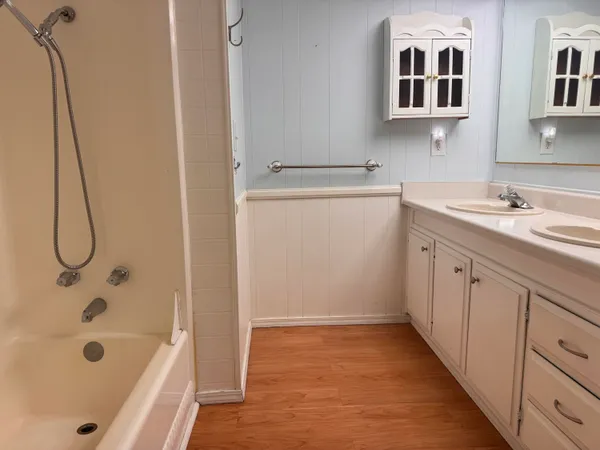 a bathroom with a tub sink and mirror