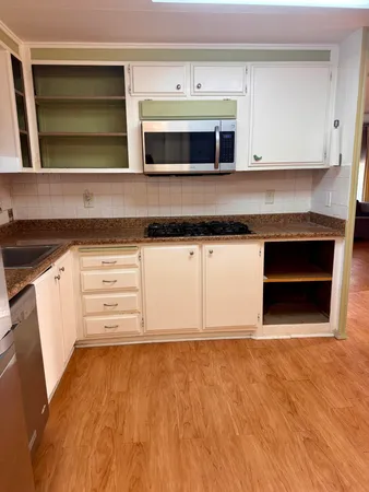 a kitchen with granite countertop a stove and a microwave oven