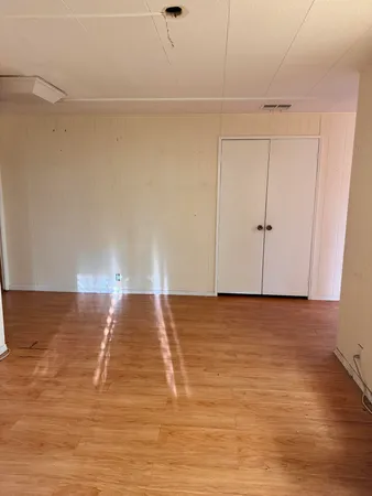 a view of empty room with wooden floor