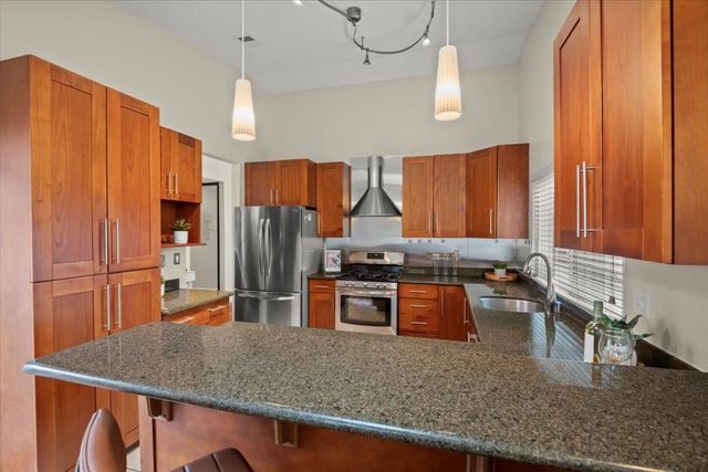 a kitchen with stainless steel appliances granite countertop a sink refrigerator and microwave