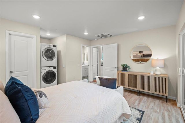 a bedroom with a bed a mirror on dresser and a chandelier