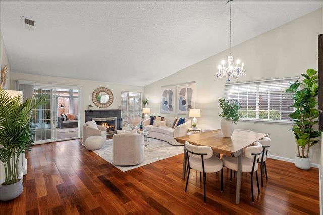 a view of a dining room with furniture a chandelier and wooden floor