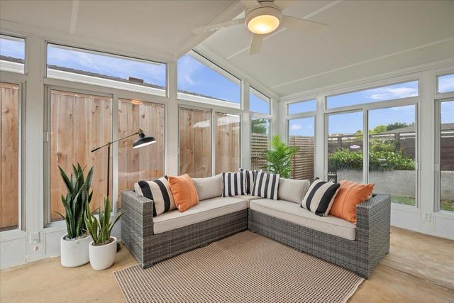 a living room with furniture and a potted plant