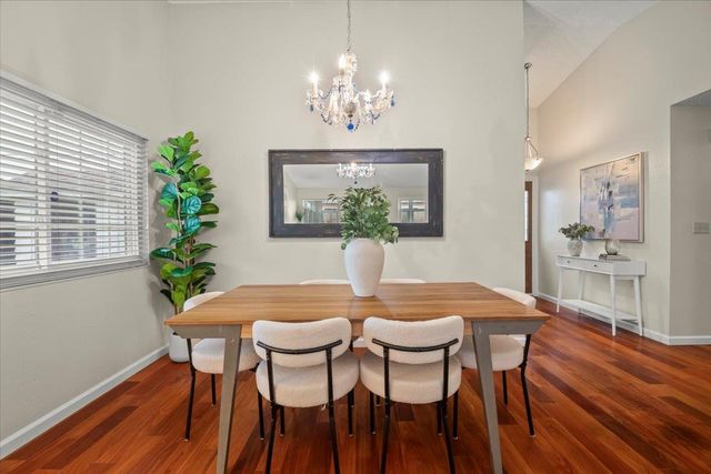 a dining room with furniture a chandelier and wooden floor
