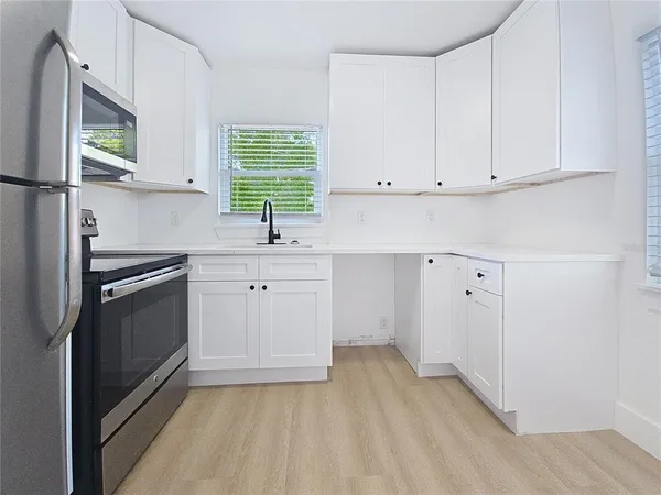 a kitchen with granite countertop a sink stainless steel appliances and cabinets