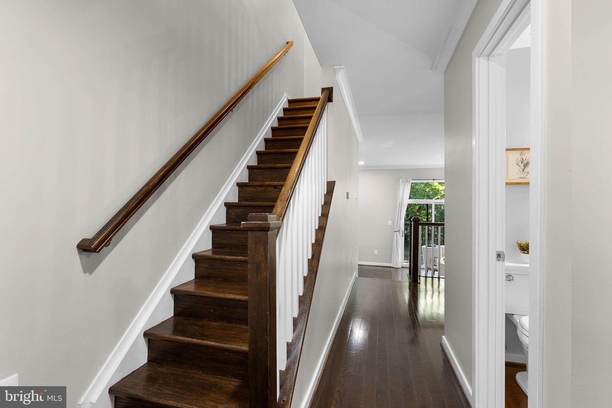 2050 Golf Course Drive Reston, VA 20191 - Photo 3 of 40 a view of staircase with wooden floor and lots of frames on wall