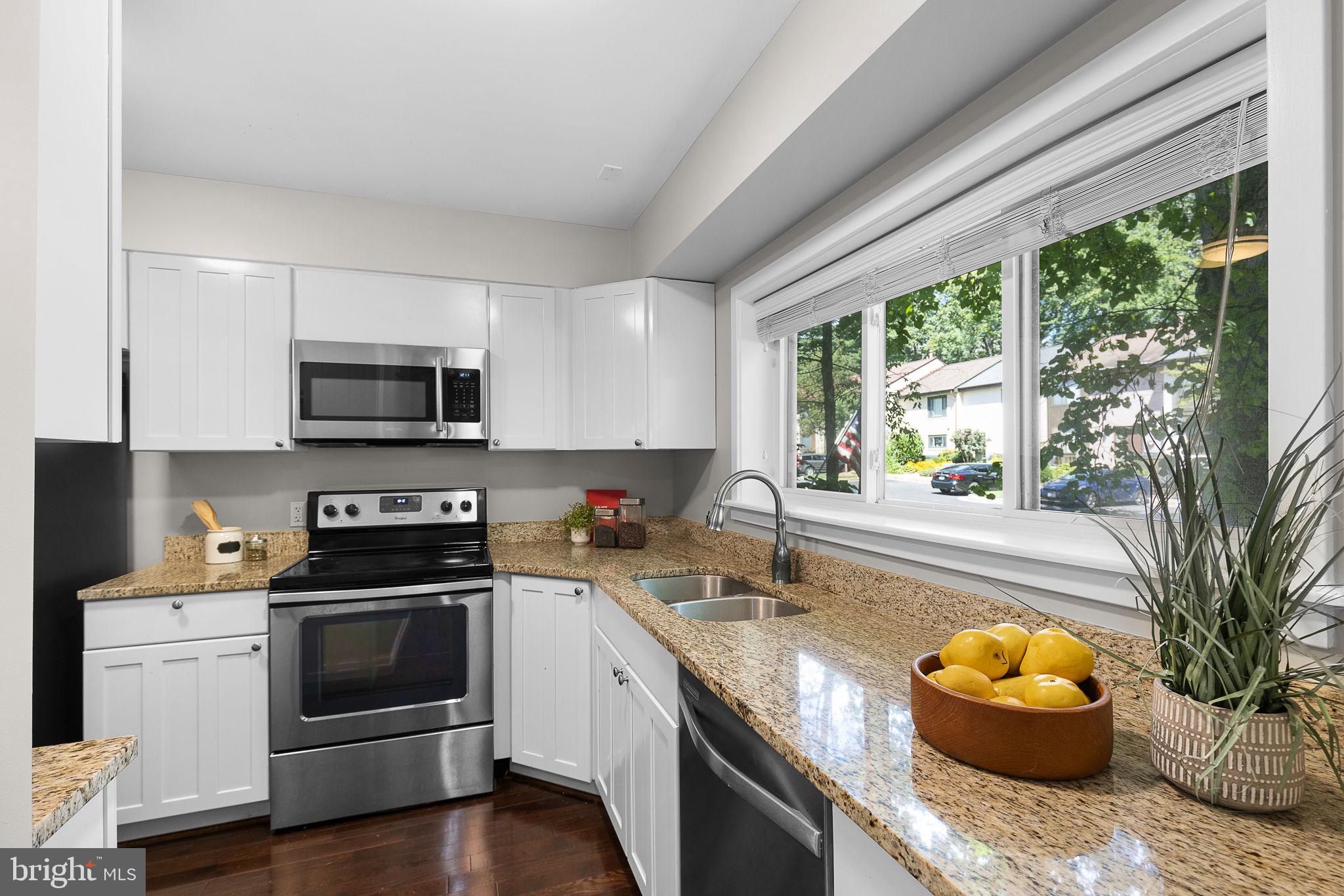 2050 Golf Course Drive Reston, VA 20191 - Photo 4 of 40 a kitchen with granite countertop a sink a stove and cabinets
