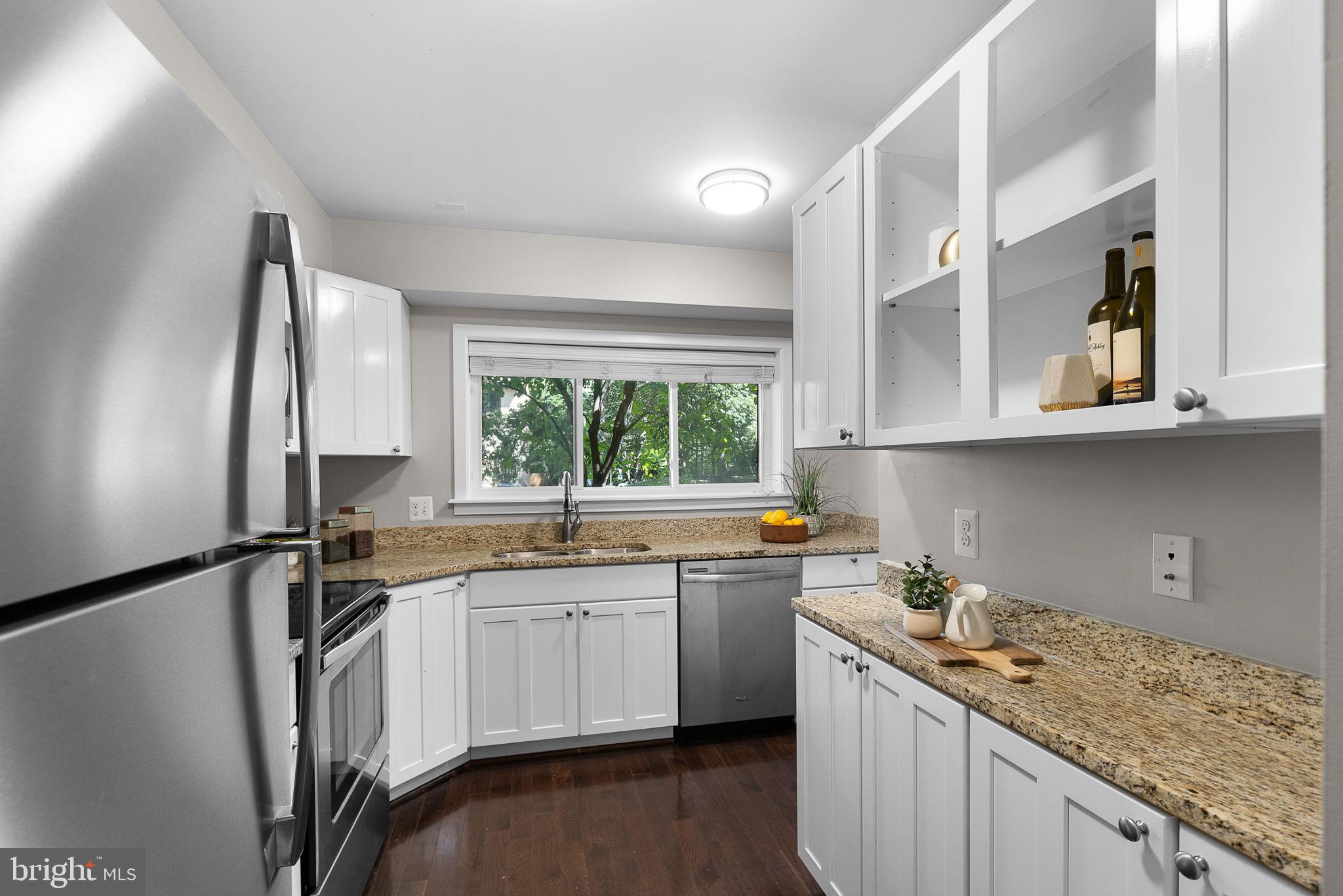 2050 Golf Course Drive Reston, VA 20191 - Photo 9 of 40 a kitchen with stainless steel appliances granite countertop a sink stove and refrigerator