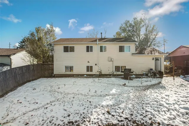 a view of a white house with wooden walls and potted plants