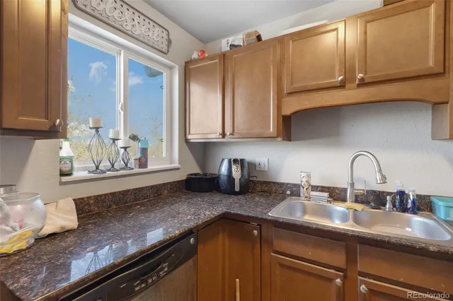 a kitchen with granite countertop stainless steel appliances a sink stove and cabinets