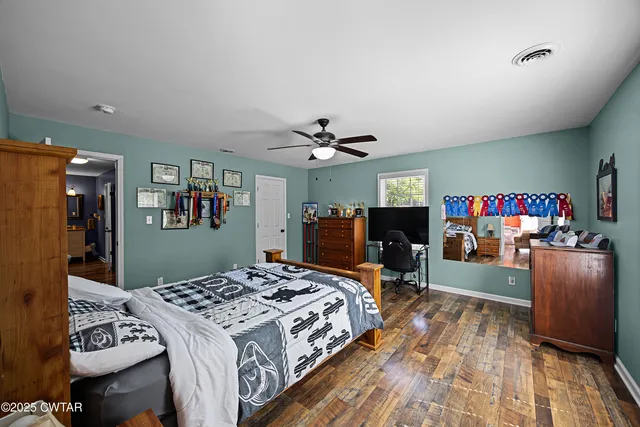 a bedroom with a bed and wooden floor