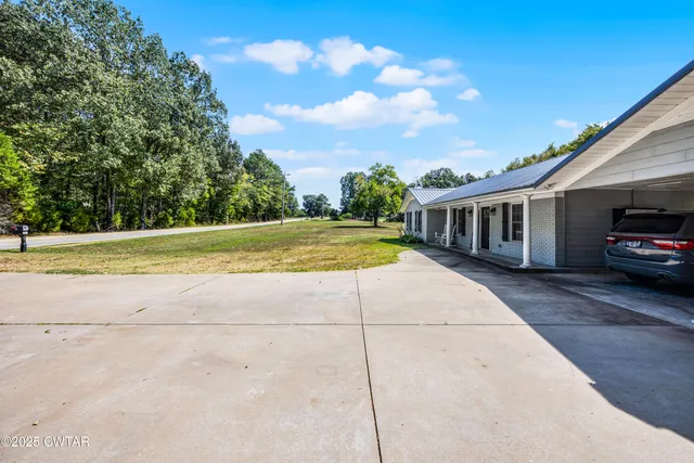 a view of a house with backyard and sitting area
