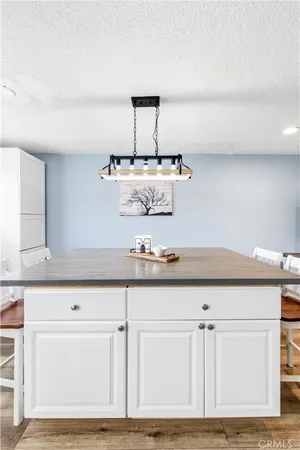 a view of a dining room and livingroom with furniture wooden floor a chandelier