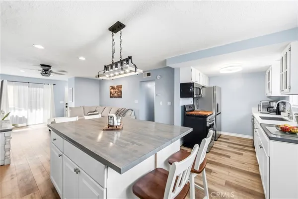 a kitchen with stainless steel appliances granite countertop a stove a sink and a microwave