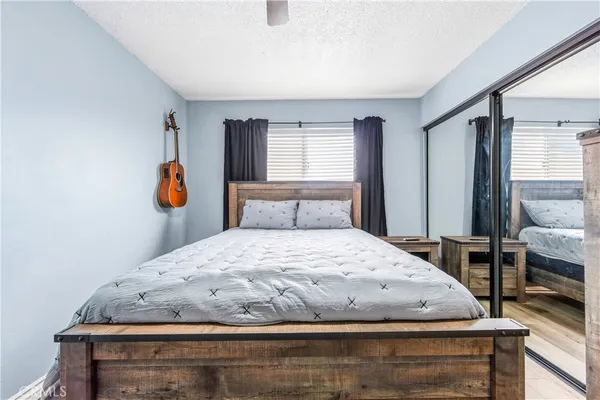 a bedroom with a large bed a chandelier and a window