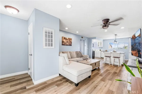 a living room with furniture a flat screen tv and kitchen view