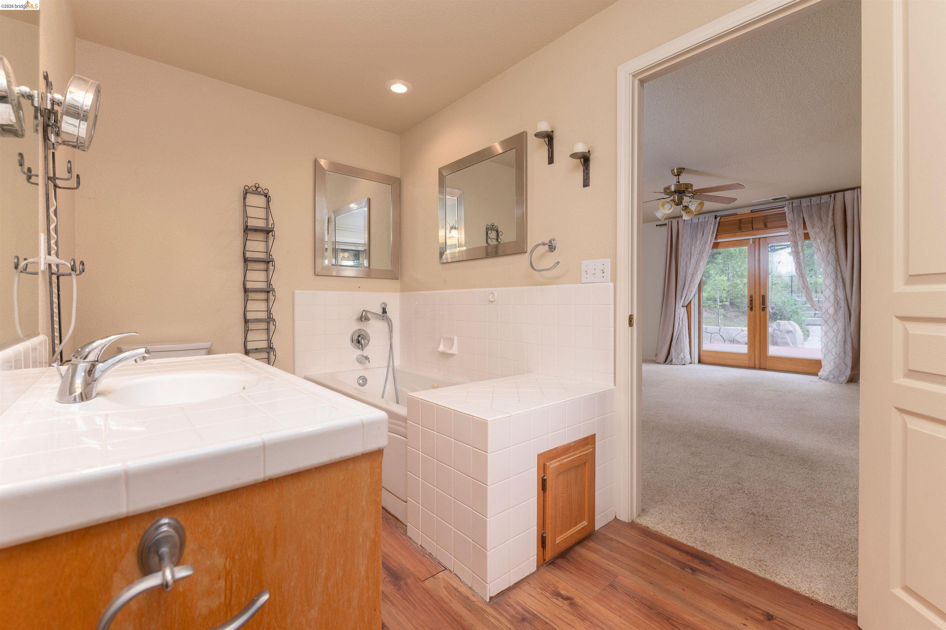 22401 Ridge Road Twain Harte, CA 95383 - Photo 17 of 56 Bathroom featuring a single vanity with tiled countertop, an undermount sink, and wood-finish cabinetry
