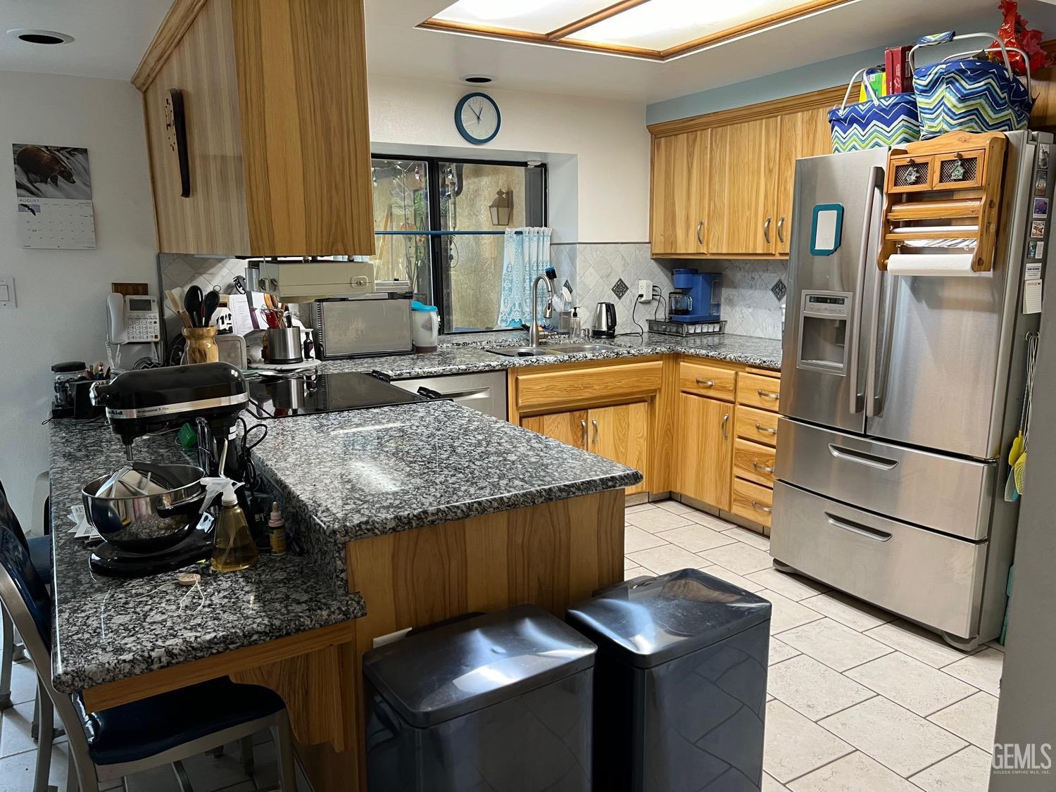 Undisclosed Address Bakersfield, CA 93311 - Photo 6 of 14 a kitchen with granite countertop kitchen island stainless steel appliances a stove a sink and a refrigerator