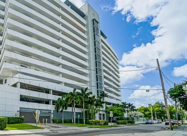 a view of a tall building next to a yard