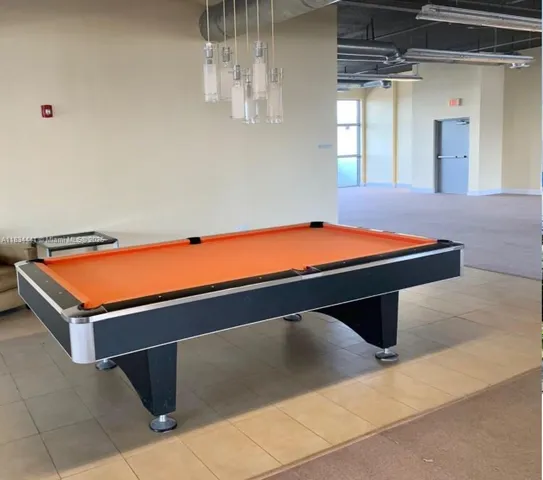 a room with pool table and windows