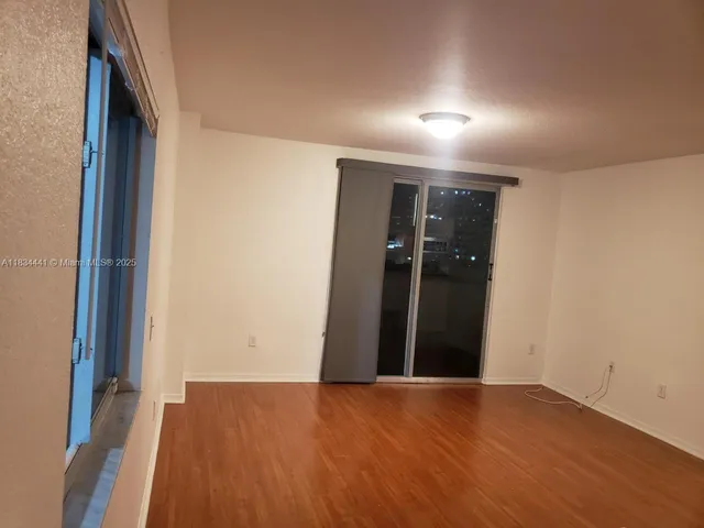 an empty room with wooden floor and closet