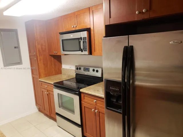 a kitchen with stainless steel appliances granite countertop a refrigerator and a stove