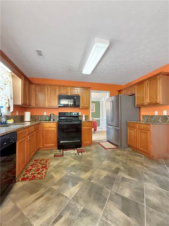 235 Shiver Boulevard Covington, GA 30016 - Photo 10 of 27 a kitchen with stainless steel appliances granite countertop a stove a sink and a refrigerator