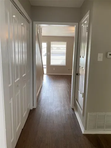 a view of a hallway with wooden floor and staircase