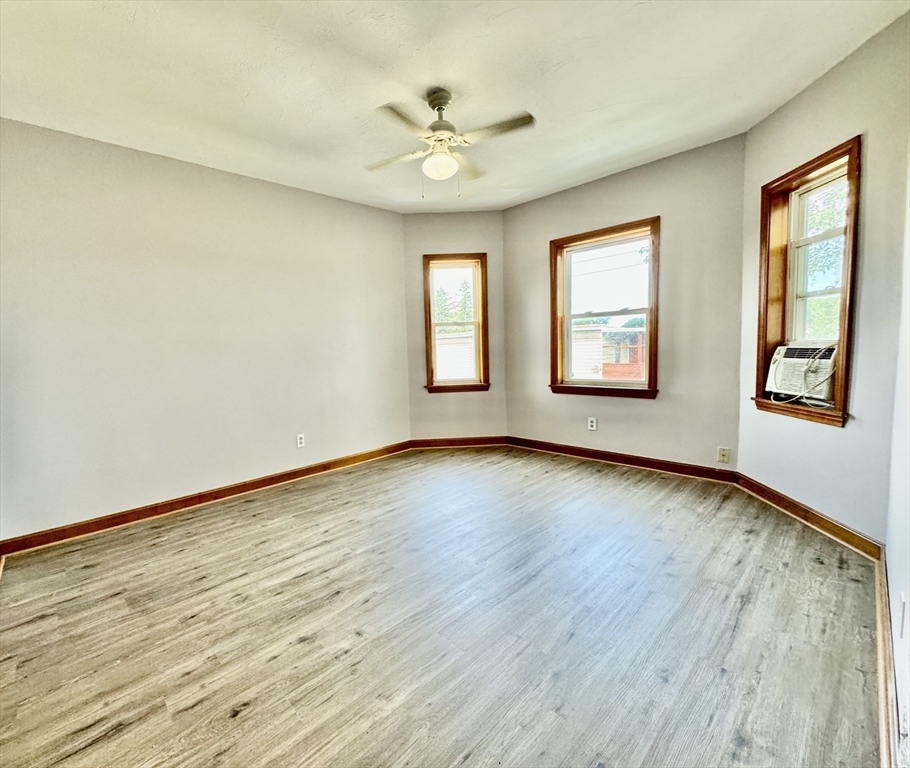 7 Rawson Road, Unit 1 Quincy, MA 02170 - Photo 2 of 17 a view of an empty room with a window and wooden floor