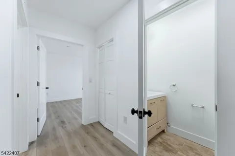 a view of a hallway with wooden floor and closet
