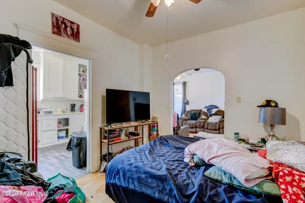 a bedroom with bed a flat tv and a couch
