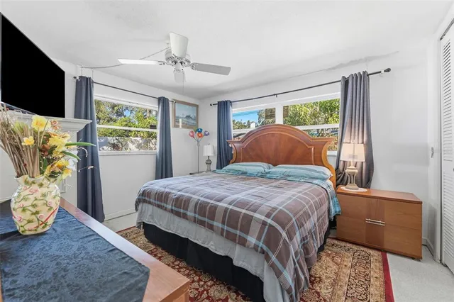 a bedroom with a bed television and a window