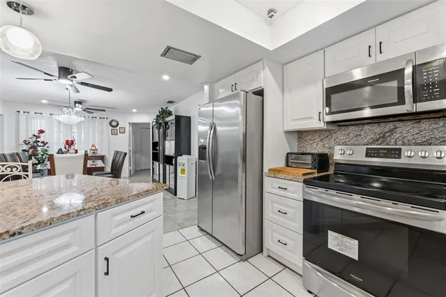 a kitchen with stainless steel appliances granite countertop a stove a refrigerator and a microwave