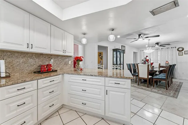 a kitchen with white cabinets and sink