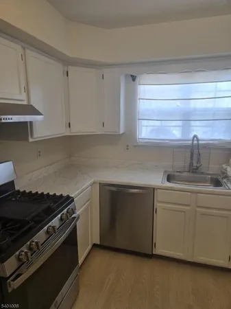 a kitchen with stainless steel appliances a sink and cabinets