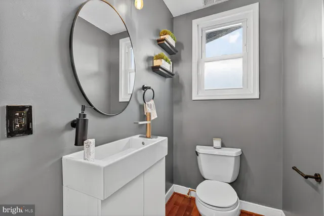 a kitchen with stainless steel appliances granite countertop wooden cabinets a stove a sink and a wooden floor