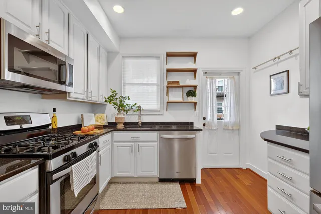 a kitchen with white cabinets and white appliances