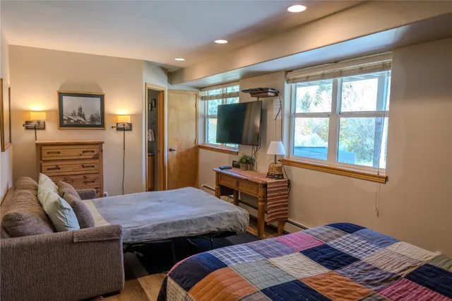 a bedroom with a bed a large window and couch