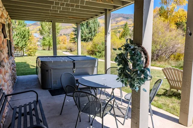 a patio table and chairs with potted plants