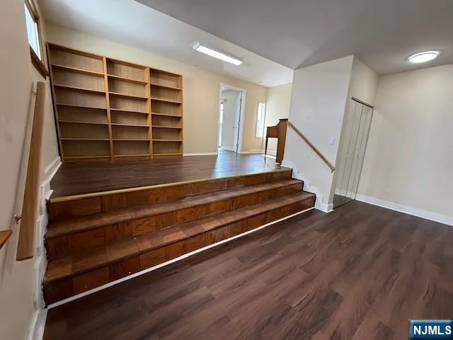 a view of room with wooden floor and stairs