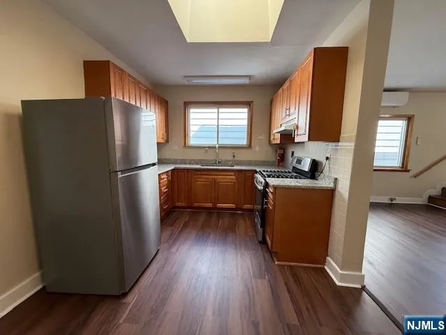 a kitchen with sink a refrigerator and wooden floor