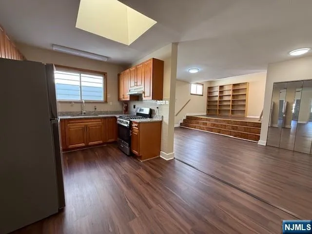 a kitchen with stainless steel appliances granite countertop wooden floors and sink