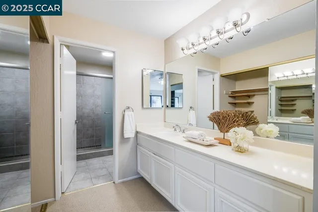a bathroom with a double vanity sink mirror and shower