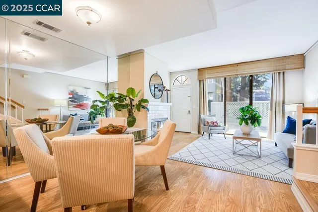 a dining room with furniture potted plants and wooden floor