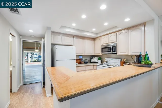 a kitchen with sink refrigerator and microwave