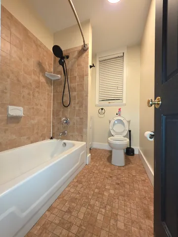 a bathroom with a toilet and a bath tub