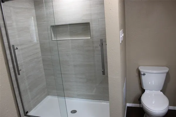 a bathroom with a toilet and a shower