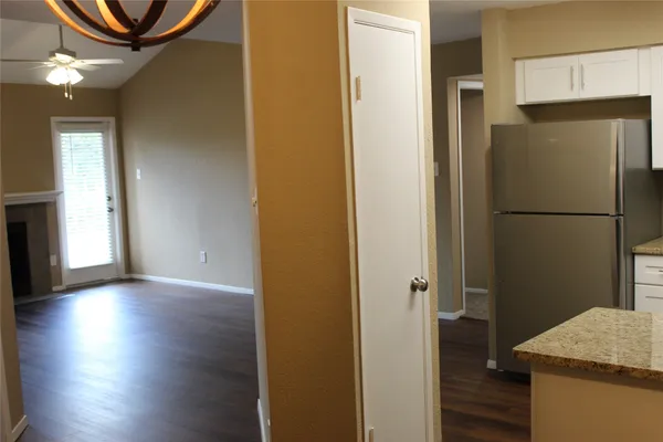 a view of a kitchen with a refrigerator and wooden floor